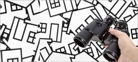 Binoculars held over cutout homes illustration